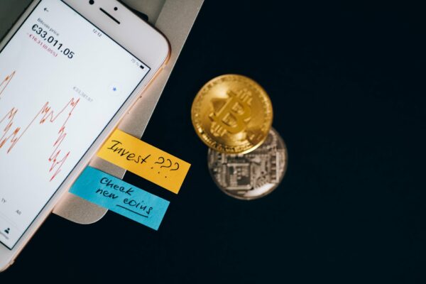 Smartphone affichant un cours Bitcoin avec piece bitcoin doree, illustrant les cycles de halving et l'investissement en 2026